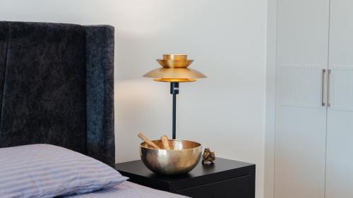 a lamp on a night stand next to a bed at Mykonos Homes - Stilvolles Apartment mit eigenem Jaccuzzi in Bahçeli