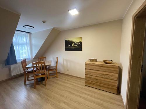 a dining room with a table and a wooden dresser at Apartmány U Bernharda in Vítkov