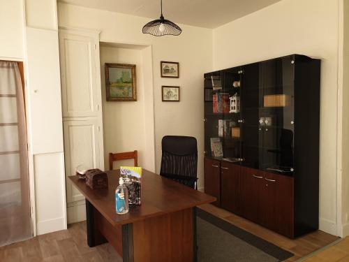 - un salon avec un bureau et un grand centre de divertissement dans l'établissement maison de ville - Le Silodort, à Vatan