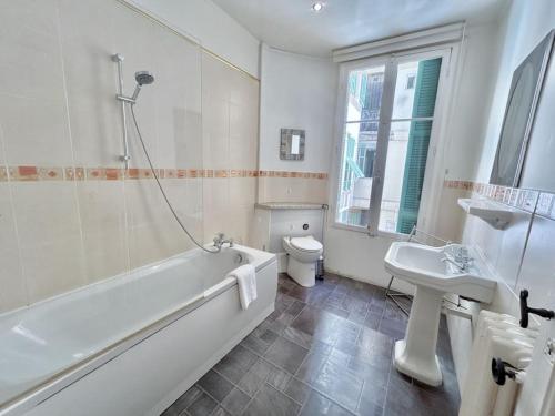 une salle de bain avec une baignoire, des toilettes et un lavabo dans l'établissement Charmant 3P en centre ville, spacieux et calme, à Nice
