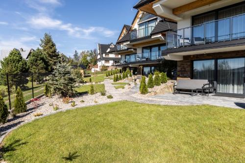 a house with a lawn in front of it at Domki przy Szlaku Pod Gubałówką in Zakopane