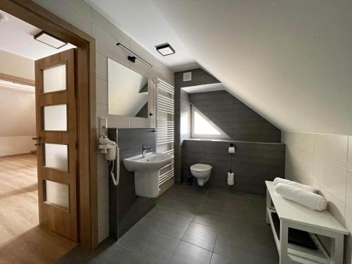 a bathroom with a sink and a toilet and a staircase at Apartmány U Bernharda in Vítkov