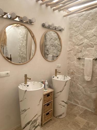 a bathroom with two sinks and two mirrors at Cortijo Boutique Marbella in Marbella