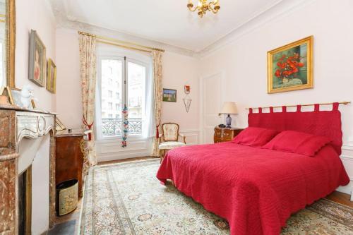 - une chambre avec un lit rouge et une cheminée dans l'établissement Superb 4 bdrms 185m2 Apt Trocadero, à Paris