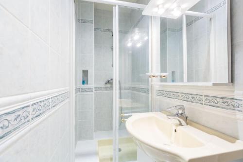 une salle de bain blanche avec un lavabo et une douche dans l'établissement Superb 4 bdrms 185m2 Apt Trocadero, à Paris