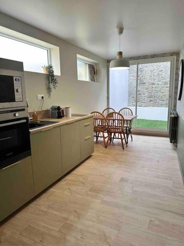 une cuisine et une salle à manger avec une table et des chaises dans l'établissement Petite maison de ville, à Avranches