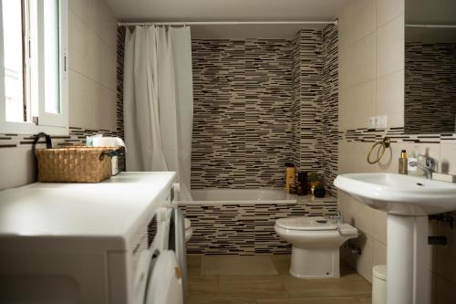 a bathroom with a sink and a toilet and a tub at SUNSHINE House in Alicante
