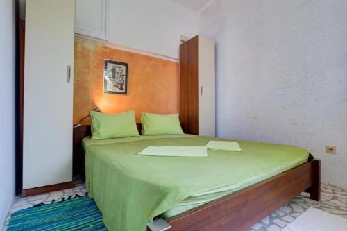 a bedroom with a large bed with green sheets at Vila Gloria in Bar