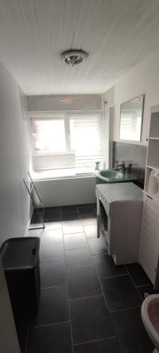 une petite cuisine avec un évier et une fenêtre dans l'établissement Maison, proche de Lille et grand stade olympique, à Lezennes