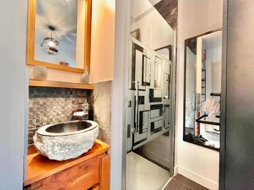a bathroom with a stone sink and a shower at Chambre avec terrasse chez l'habitant dans appartement moderne in Neuilly-sur-Seine