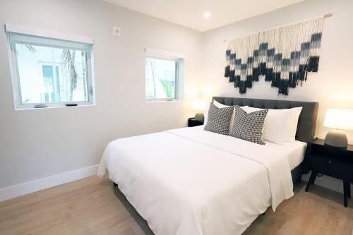 a bedroom with a large white bed and a window at Townhouse in Heart of South Beach Miami Steps to Sea in Miami Beach