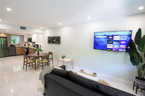 a living room with a couch and a tv on a wall at Townhouse in Heart of South Beach Miami Steps to Sea in Miami Beach