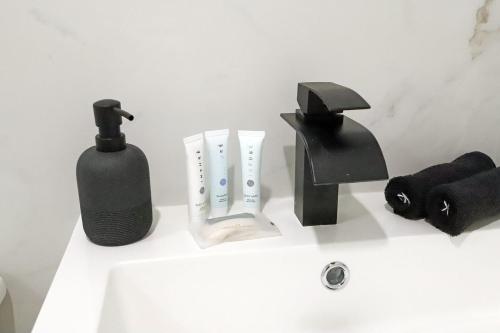 a bathroom sink with black and white items on it at Townhouse in Heart of South Beach Miami Steps to Sea in Miami Beach