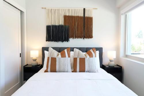 a bedroom with a white bed with pillows and two lamps at Townhouse in Heart of South Beach Miami Steps to Sea in Miami Beach
