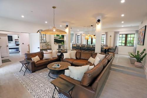 a living room with brown couches and a table at 6 Bedroom Villa with Pool & Parking in Heart of South Beach Miami in Miami Beach