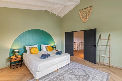 Jan ThielにあるLa Casa Blanca Curaçaoの緑のヘッドボードが付いた大きなベッドのある寝室