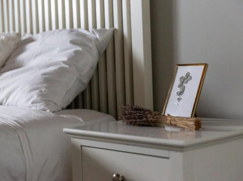 a white bed with a table with a picture on it at SUNSHINE House in Alicante