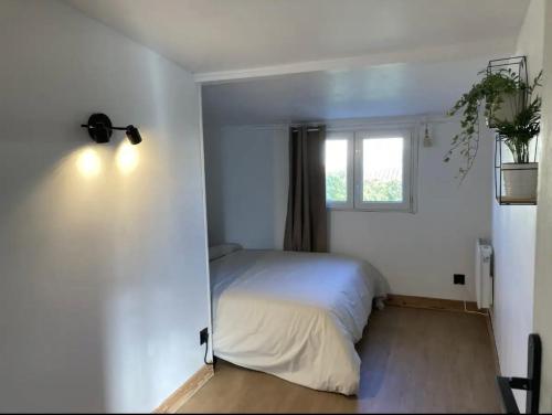 une chambre avec un lit blanc et une fenêtre dans l'établissement Charmante maison climatisée avec piscine privée, à Avignon