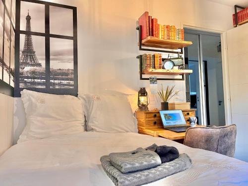 a bedroom with a bed and a laptop on a desk at Chambre avec terrasse chez l'habitant dans appartement moderne in Neuilly-sur-Seine