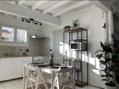 une salle à manger avec une table et des chaises et une cuisine dans l'établissement Charmante maison climatisée avec piscine privée, à Avignon