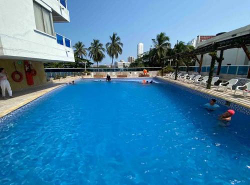 a group of people swimming in a large swimming pool at Apartamento remodelado cómodo y cerca al mar in Cartagena de Indias