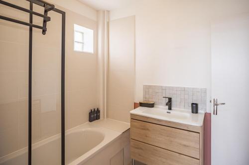 La salle de bains est pourvue d'une baignoire, d'un lavabo et d'une baignoire. dans l'établissement Évasion Urbaine - Chambre 2 - Hypercentre, à Troyes
