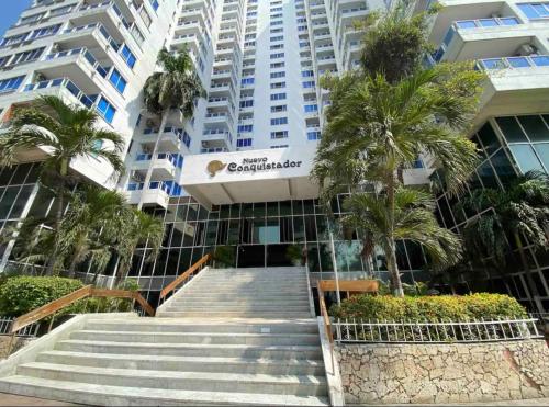 a staircase leading to a large building with palm trees at Apartamento remodelado cómodo y cerca al mar in Cartagena de Indias