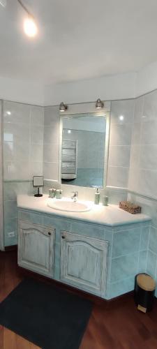 a bathroom with a sink and a mirror at Bienvenue à Longère Bihan - Bed & Breakfast in Plévin