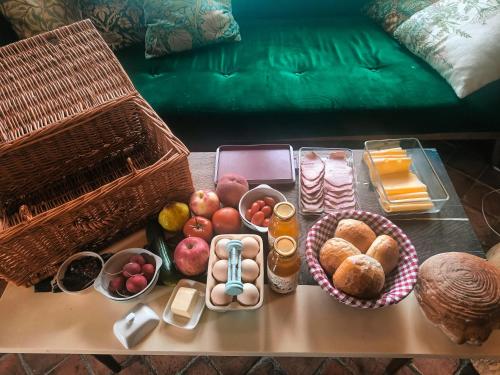 a table topped with baskets of food on top of a couch at Jurty z widokiem, prywatna balia- DZIKOLAS GLAMPING in Krasnobród