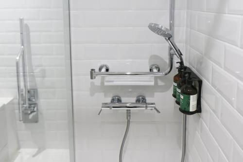 a shower in a bathroom with a glass door at voco Oxford Spires by IHG in Oxford