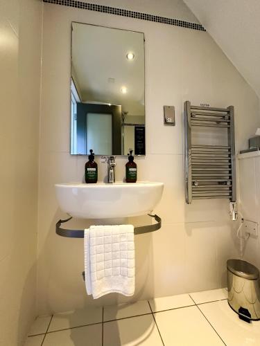 a bathroom with a sink and a mirror at voco Oxford Spires by IHG in Oxford
