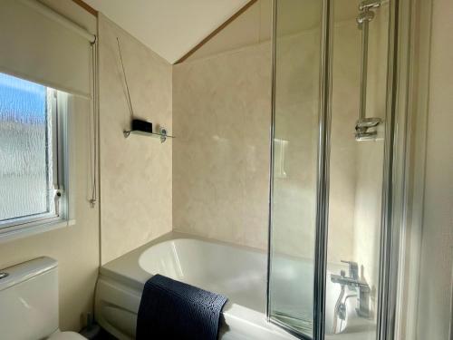 a bathroom with a shower and a bath tub at Stunning 2 Bed Caravan on the Lake Front in Gloucestershire