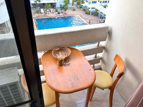 a table and chairs in a balcony with a swimming pool at Cozy 1br walk to BTS and Airport Rail Link Close to Malls M11 in Bangkok