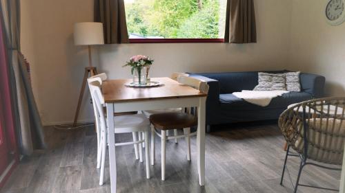 a living room with a table and a couch at Camping De Bosrand in Sint Geertruid