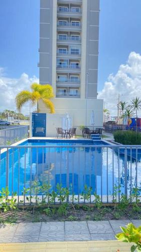 a swimming pool in front of a tall building at 1204 Apto 2 Quartos Cabedelo Ponta de Campina Cabedelo TAXA DE ENERGIA E LIMPEZA SÃO COBRADAS NO CHECK-IN E CHECK-OUT in Cabedelo