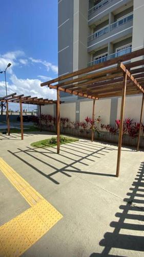 a row of wooden benches in front of a building at 1204 Apto 2 Quartos Cabedelo Ponta de Campina Cabedelo TAXA DE ENERGIA E LIMPEZA SÃO COBRADAS NO CHECK-IN E CHECK-OUT in Cabedelo