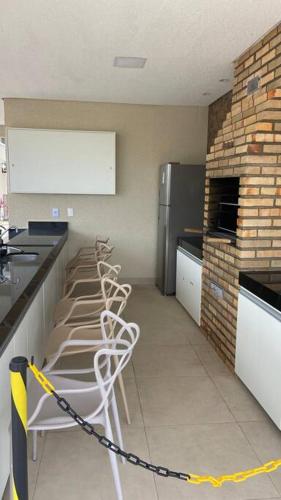 a kitchen with a bunch of chairs chained to a counter at 1204 Apto 2 Quartos Cabedelo Ponta de Campina Cabedelo TAXA DE ENERGIA E LIMPEZA SÃO COBRADAS NO CHECK-IN E CHECK-OUT in Cabedelo