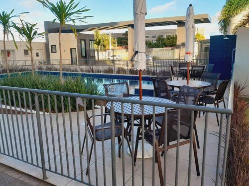 a patio with a table and chairs next to a pool at 1204 Apto 2 Quartos Cabedelo Ponta de Campina Cabedelo TAXA DE ENERGIA E LIMPEZA SÃO COBRADAS NO CHECK-IN E CHECK-OUT in Cabedelo
