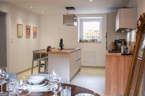 a kitchen with a counter and a table with wine glasses at Chambre Pin Up Wings in Eguisheim