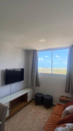 a living room with a large window and a television at 1204 Apto 2 Quartos Cabedelo Ponta de Campina Cabedelo TAXA DE ENERGIA E LIMPEZA SÃO COBRADAS NO CHECK-IN E CHECK-OUT in Cabedelo