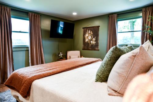a bedroom with a bed and a tv on the wall at The Bidwell Bungalow in Amanda
