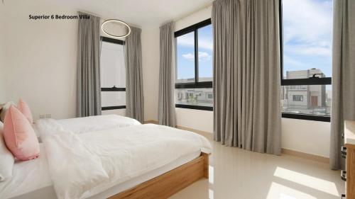 a bedroom with a bed and a large window at Al Dana Paradise Luxury Villas Palm Fujairah Sea View in Fujairah