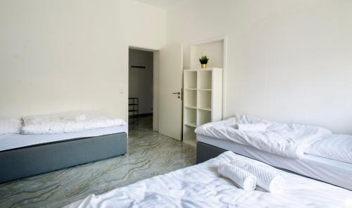 a room with two beds and a room with a closet at Stay & Work Apartment Rheine in Rheine