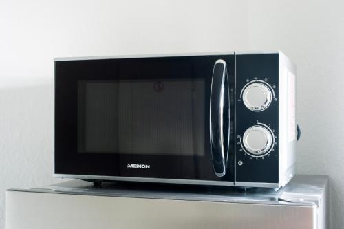 a microwave oven sitting on top of a shelf at Stay & Work Apartment Rheine in Rheine