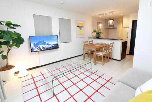 a living room with a table and a kitchen at Naka HOUSE in Tokyo