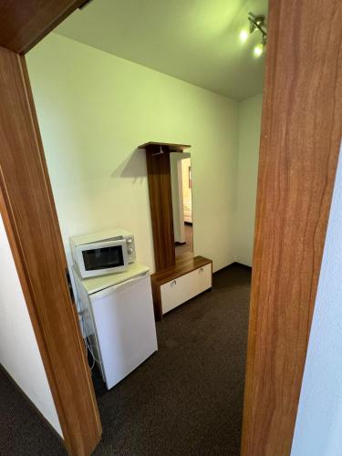 an empty room with a microwave and a refrigerator at Pension Zur Traube 2 in Bergheim