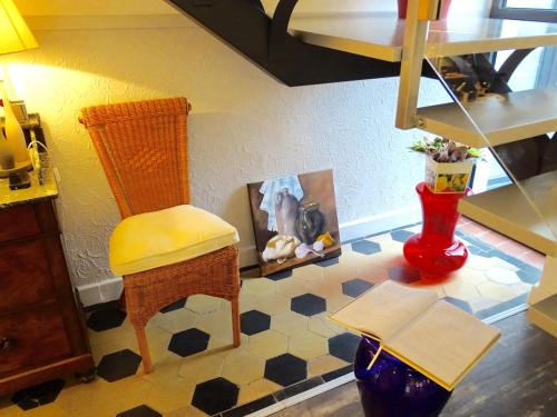 a living room with a chair and a table at Les Myosotis Chambres d'hôtes - Sarreguemines in Zetting