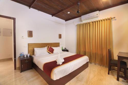 a bedroom with a large bed with a desk and a bed sidx sidx at Vajra Ayurveda and Yoga Retreat in Cochin