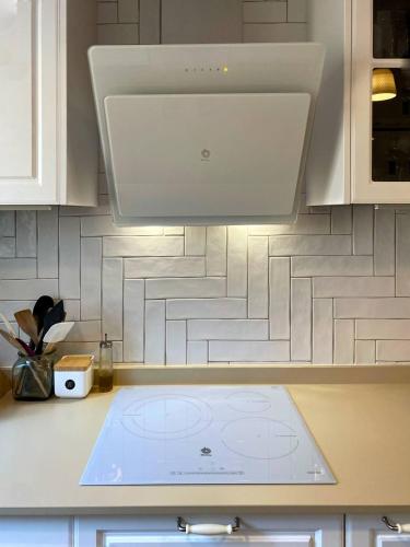 a kitchen with a white counter top with a hood at El Rincón de Deveses in Denia