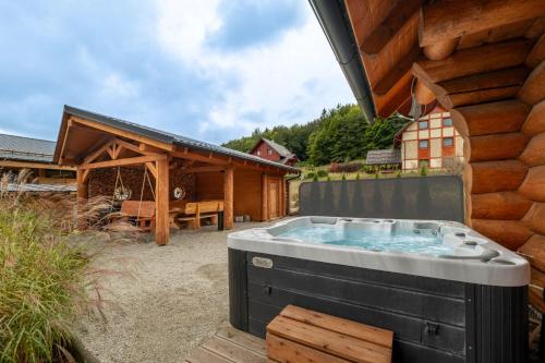 a hot tub in a yard next to a building at Zrub Jánošík in Valča